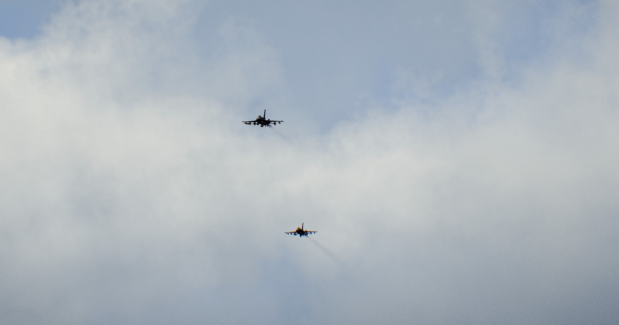 Two jets flying in formation through a cloudy sky in Arma 3.